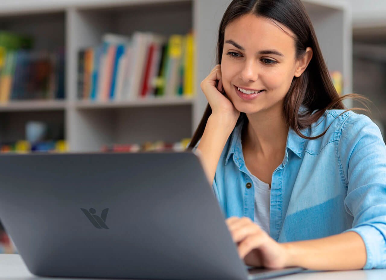 Estudiante de Posgrado con laptop en una biblioteca